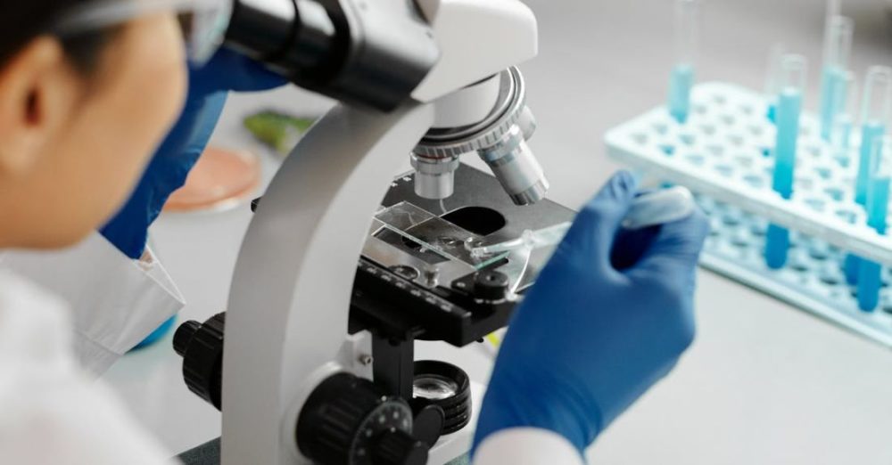 Scientific Experience - Photo of a Scientist Using a Dropper on a Microscope