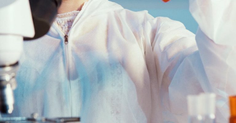 Scientific Technology - A Woman Holding While Looking at a Test Tube