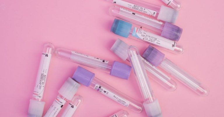 Scientific Research - Set of blood test vials arranged on pink table