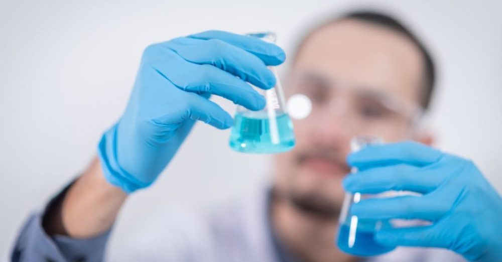 Scientist - Person Holding Glass Flasks