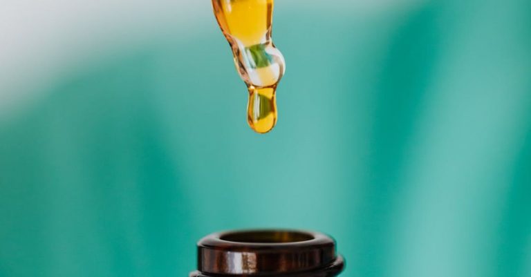 Scientific Research - Closeup of anonymous doctor with pipette for fluid dripping yellow medication in brown glass vial while making procedure in clinic